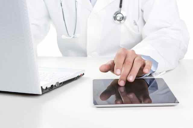 medico trabalhando com um tablet