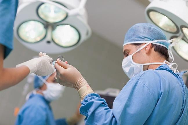 médicos cirurgiões se preparando para paciente com trauma com risco de hemorragia aguda