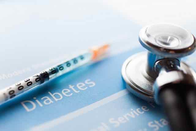 estetostocopio e uma siringa em um teste de diabetes