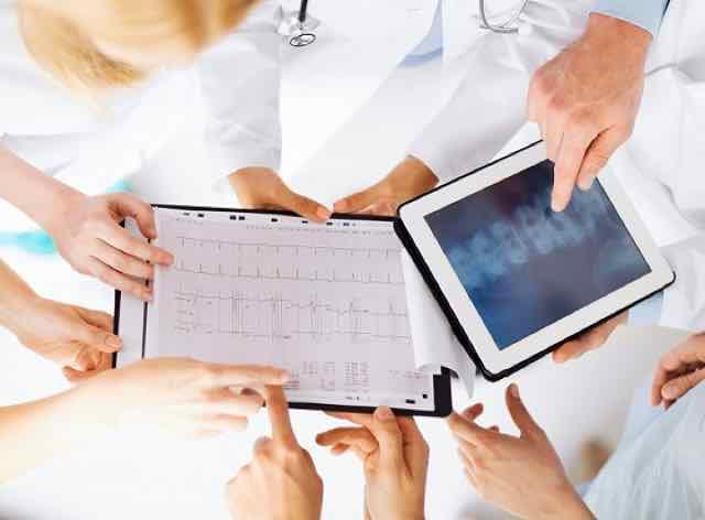 grupo de médicos olhando para um ECG