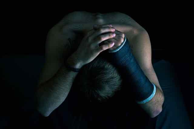 homem com a cabeça baixa, em depressão