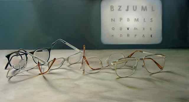 oculos em cima da mesa e tabela com letras no fundo
