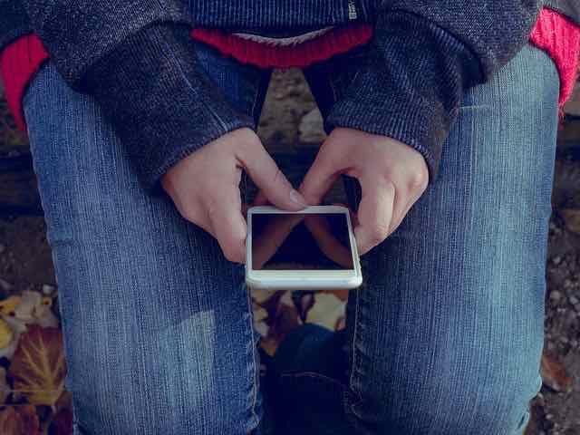 mulher sentada segurando um iphone