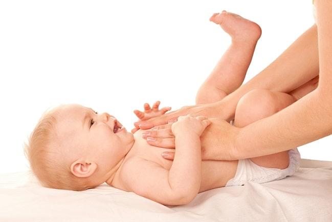 bebê com cólicas infantis recebendo massagem