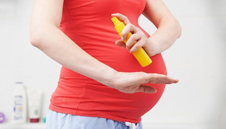 Mulher grávida usando repelentes