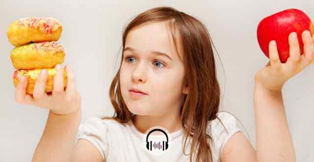 criança com uma maçã em uma mão e donuts em outra