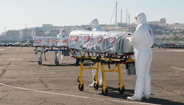 médicos transferindo pacientes com ebola