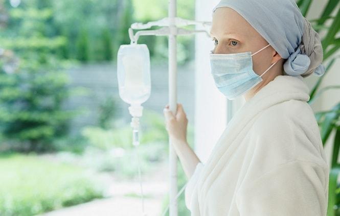 paciente com câncer de mama fazendo quimioterapia enquanto olha pela janela