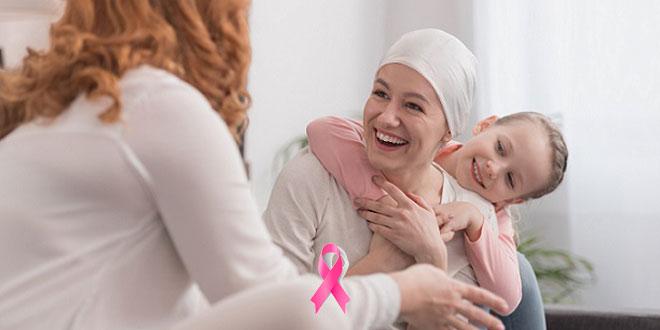 mulher com câncer de mama rindo e brincando com outras pessoas