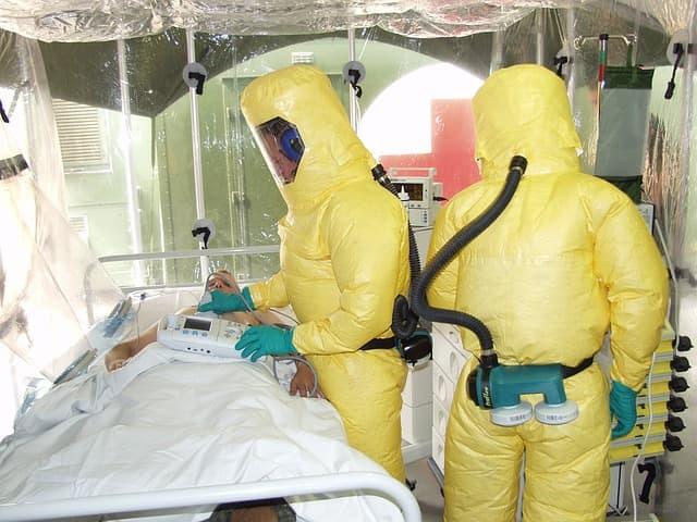 médicos em isolamento de paciente com ebola, consultando o paciente