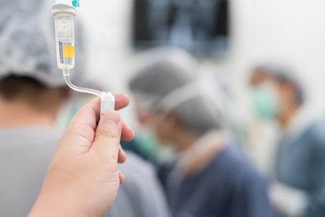 mão de médico realizando infusão de anticorpo monoclonal contra a covid-19