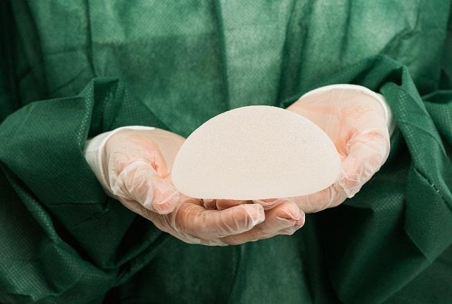 médico segurando implante mamário