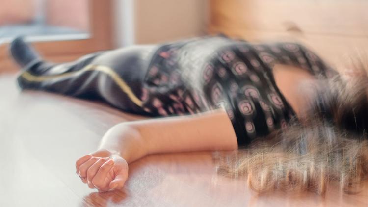 Mulher jovem caída ao chão em status epilepticus