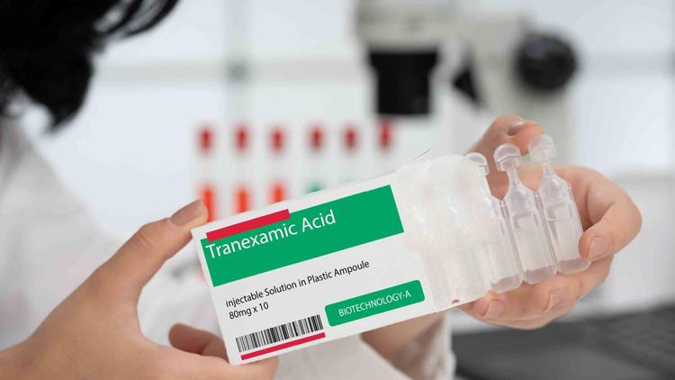 Profissional de saúde manipulando caixa de ácido tranexâmico