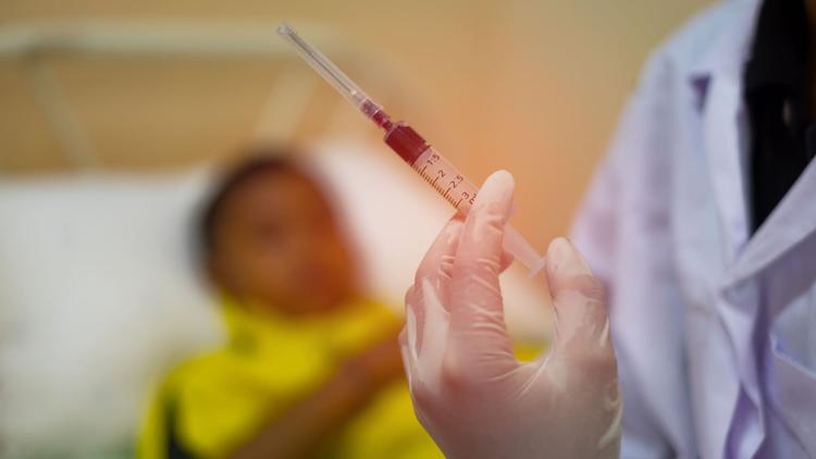 Paciente internado com dengue recebendo medicação