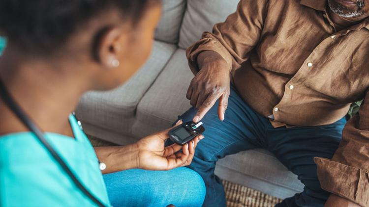 Enfermeira medindo glicose de paciente com DM2