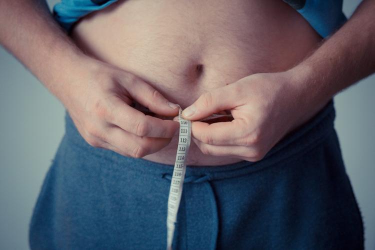 homem obeso com fita métrica
